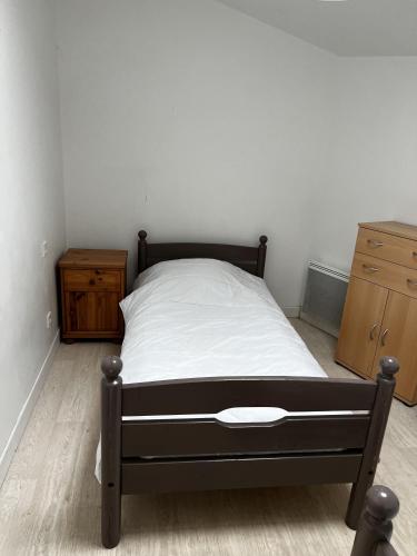 a bedroom with a bed and two wooden cabinets at Gite Camélia in La Réorthe