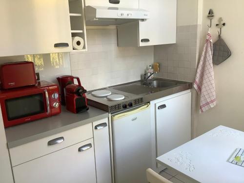 une petite cuisine avec un micro-ondes et un évier dans l'établissement Studio Rousseau, à Deauville