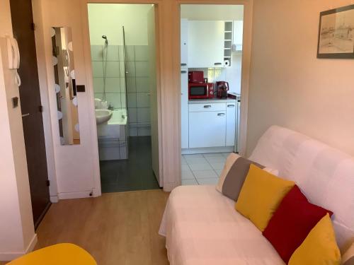 un salon avec un canapé et une cuisine dans l'établissement Studio Rousseau, à Deauville