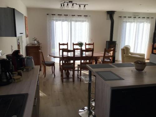 une cuisine et une salle à manger avec une table et des chaises dans l'établissement Ty Govel, à Plourhan