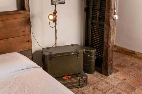 a corner of a bedroom with a bed and a suitcase at Le Suite di Borgo Casa Scaparone in Biglini