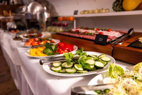 a buffet with plates of food on a table at Pytloun Wellness Hotel Hasištejn in Místo