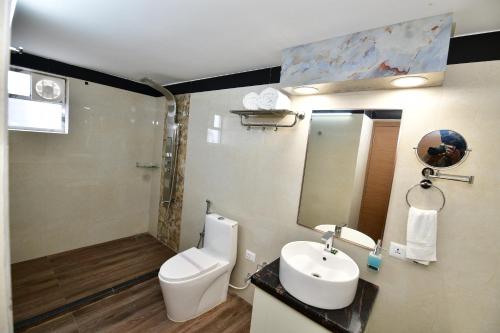 a bathroom with a toilet and a sink and a mirror at Hotel Star Bodh Gaya in Bodh Gaya