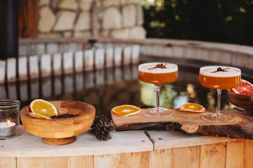 a wooden table with two glasses of orange juice at OSADA LEŚNA - domki z basenem in Stare Miasto