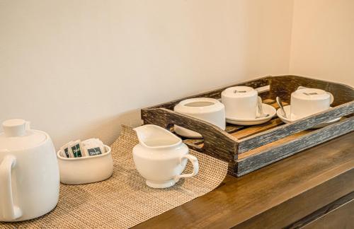 a tray filled with white cups and plates on a counter at Lindy Stays Talpe in Pitiduwa