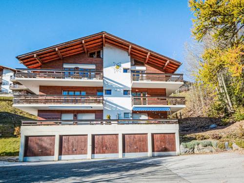 a building with two garage doors in front of it at Apartment Topaze-2 by Interhome in Anzère