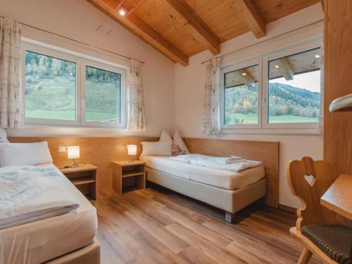 a bedroom with two beds and two windows at Apartment Ingrid by Interhome in Fusch an der Glocknerstraße