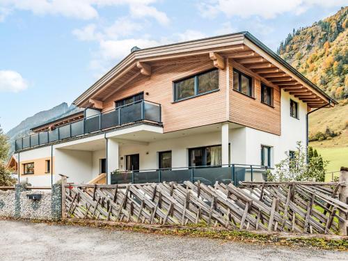 a house with a wooden roof and a fence at Apartment Ingrid by Interhome in Fusch an der Glocknerstraße