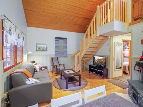 ein Wohnzimmer mit einer Couch und einer Treppe in der Unterkunft Holiday Home Immelkotsa 7 e by Interhome in Levi