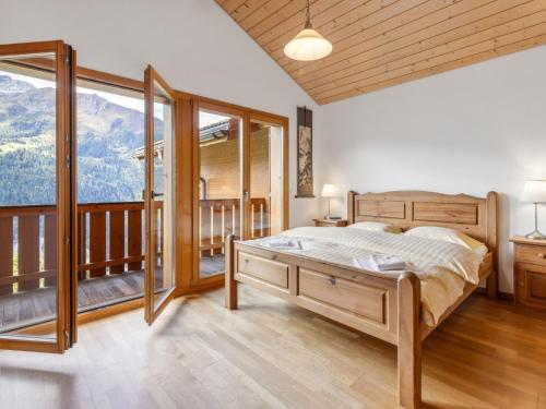 a bedroom with a bed and a balcony with mountains at Apartment Racer's Retreat Apt-07 by Interhome in Wengen