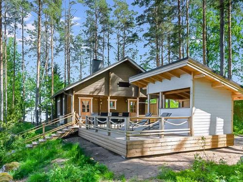 a cabin in the woods with a large deck at Holiday Home Mäntykumpu by Interhome in Petäjävesi