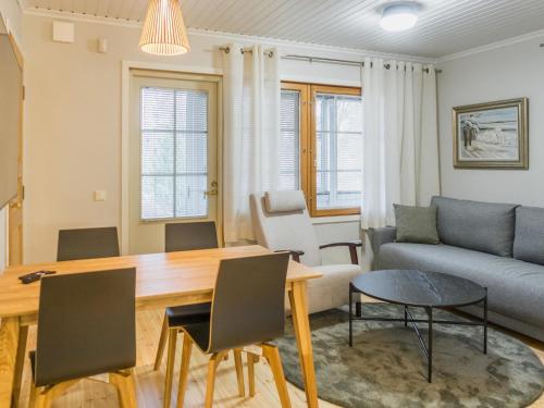 a living room with a table and a couch at Holiday Home Sammal by Interhome in Kukkola