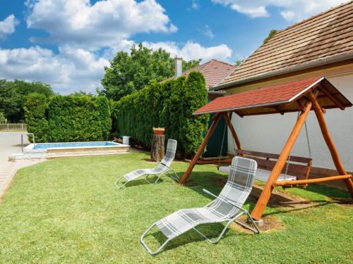 two chairs and a gazebo in a yard at Holiday Home Brigi by Interhome in Balatonszárszó