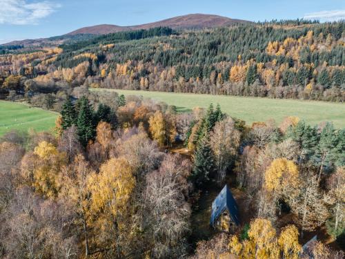 an aerial view of an old cabin in the forest at Chalet Rowan Cottage by Interhome in Inverness