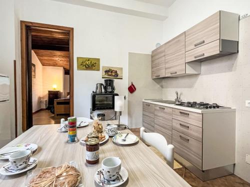 a kitchen with a wooden table with cups and plates on it at Apartment Asplanato - DOL166 by Interhome in Lecchiore