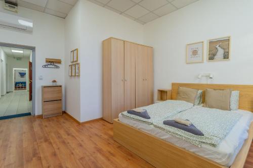 a bedroom with a large bed and a wooden cabinet at Grassalkovich Residence in Budapest