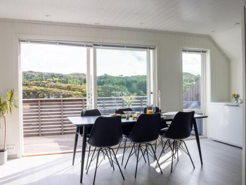 ein Esszimmer mit Tisch und Stühlen und einem großen Fenster in der Unterkunft Holiday Home Torsk by Interhome in Bømlo