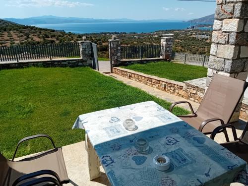 a table and chairs on a patio with a view of the ocean at Kappa house in Vélos
