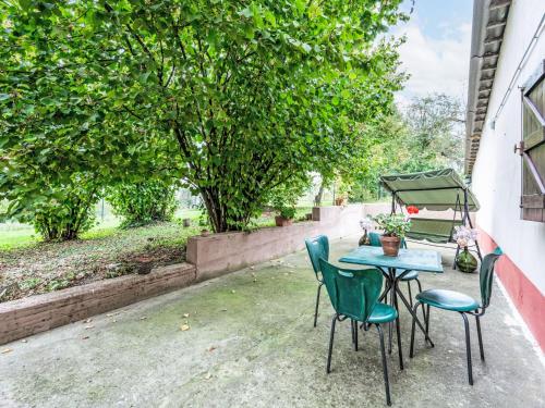 a table and chairs on a patio with trees at Apartment Casa dei Nonni by Interhome in Cascine di Pietra