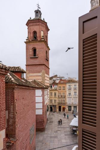 vista su un edificio con torre dell'orologio di Smartr Malaga Centro a Málaga