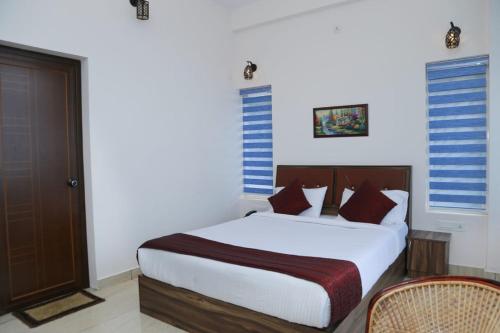 a bedroom with a large white bed and a chair at Sky Elanza in Munnar