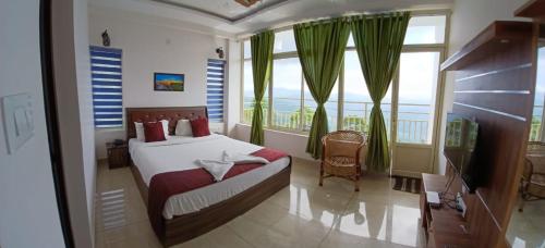 a bedroom with a bed and a large window at Sky Elanza in Munnar