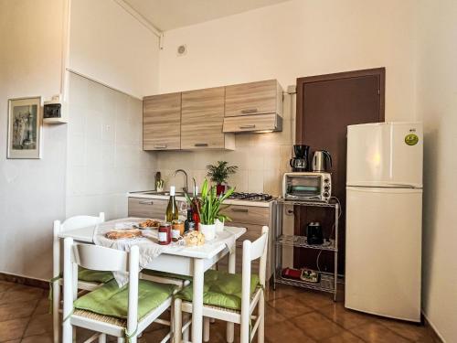 a kitchen with a white table with chairs and a refrigerator at Apartment Asplanato - DOL164 by Interhome in Lecchiore
