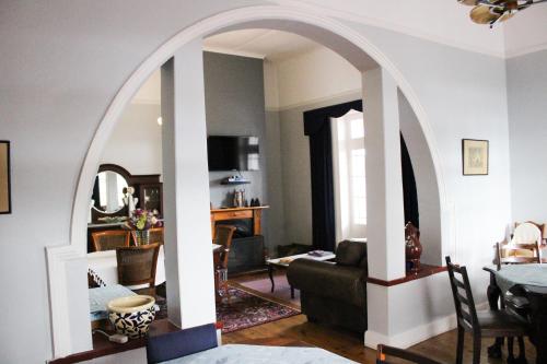 an archway in a living room with a dining room at De Oude Yotclub in Oudtshoorn