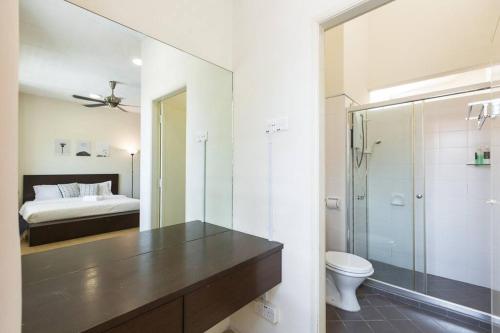 a bathroom with a shower and a toilet and a bed at Landed 3BR Home Near Beach, Seafood & Fisherman Village in Bayan Lepas