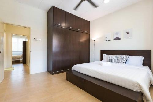 a bedroom with a large bed with a wooden headboard at Landed 3BR Home Near Beach, Seafood & Fisherman Village in Bayan Lepas