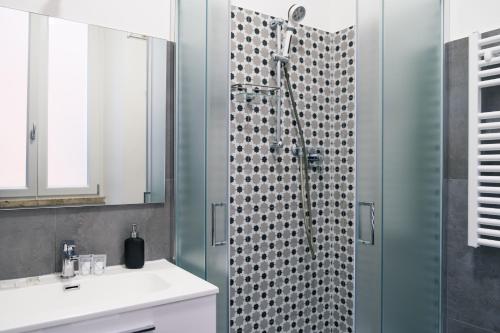 Un baño con ducha con lavabo y espejo. en Porta Romana, en Viterbo