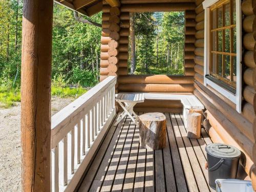 列维Holiday Home Mötönpesä 2 by Interhome的小木屋的门廊上摆放着长椅和两扇窗户。