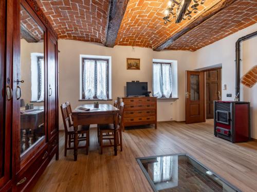 a living room with a table and chairs and a television at Holiday Home Zio-Nonno by Interhome in Portacomaro