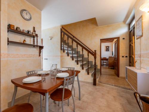 a dining room with a table and chairs and a staircase at Holiday Home Zio-Nonno by Interhome in Portacomaro