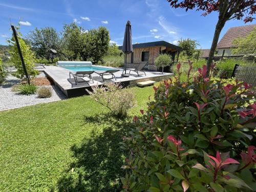une cour arrière avec une piscine, une table et des chaises dans l'établissement APPART-HOTEL n 3 avec terrasse, piscine, petit-dejeuner et parking privé, à Chouzelot
