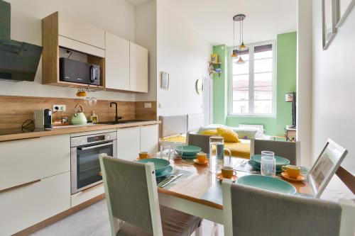 une cuisine et une salle à manger avec une table et des chaises dans l'établissement Charmant appartement à Vaise, à Lyon