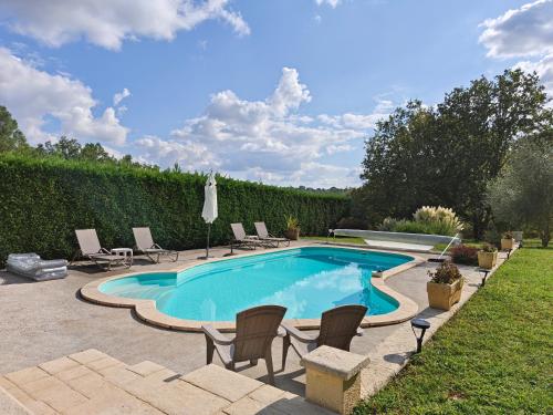 - une piscine dans une cour avec des chaises dans l'établissement Gite Le Petit Wren - avec piscine et vue, à Fumel