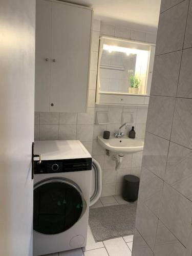 a small bathroom with a washing machine and a sink at Madelulu House in Pramanta