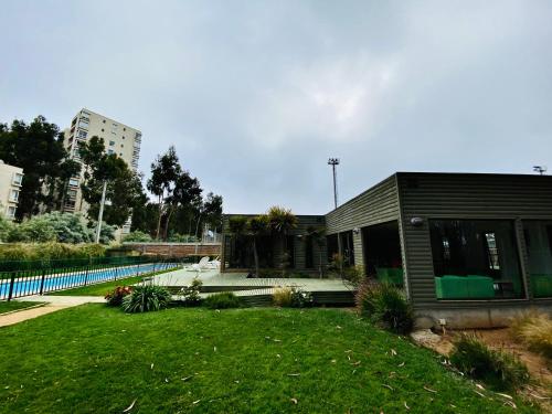 a house with a swimming pool next to a yard at Acogedor y tranquilo departamento Mirasol in Algarrobo