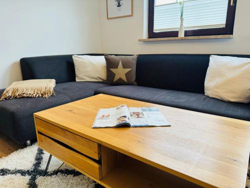 a living room with a blue couch and a coffee table at App Blaue Welle in Morsum