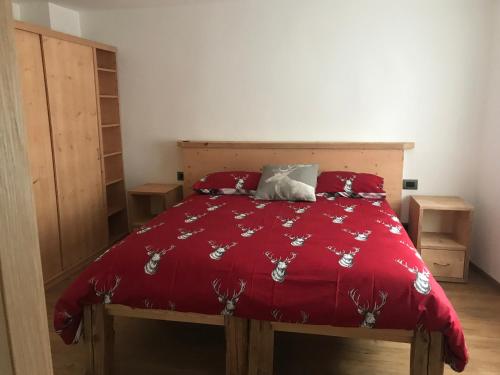 a bedroom with a bed with a red comforter at Agriturismo Quinta Essenza in Casoni Zanolla