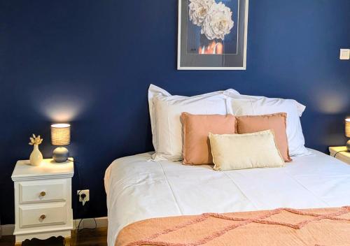 - une chambre bleue avec un lit doté de draps et d'oreillers blancs dans l'établissement Solen Évasion - L'Abalone - Vacances en Vendée, à Aizenay