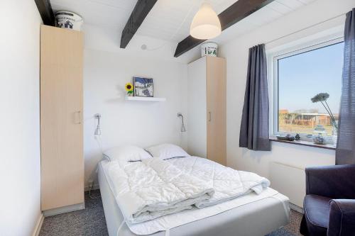 ein Schlafzimmer mit einem Bett und einem Fenster in der Unterkunft Nice Home In Ebeltoft With 4 Bedrooms, Sauna And Wifi in Ebeltoft