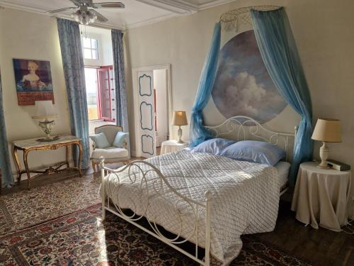 a bedroom with a bed with a blue canopy at Chateau Ventenac in Ventenac en Minervois