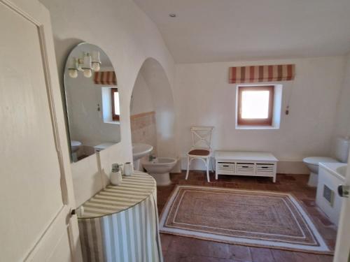 a bathroom with a sink and a toilet and a mirror at Chateau Ventenac in Ventenac en Minervois