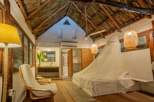 a bedroom with a bed with a mosquito net at Hotel Playa Scondida Barú in Baru