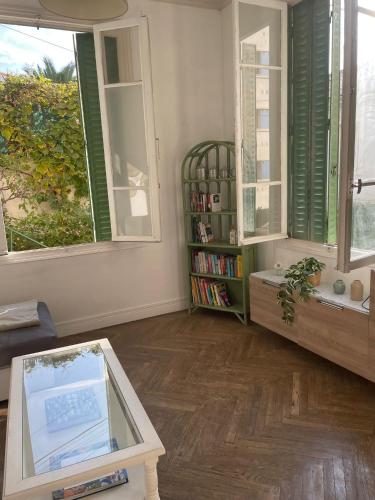 - un salon avec une étagère et des fenêtres dans l'établissement Villa Claudia Nice port, à Nice