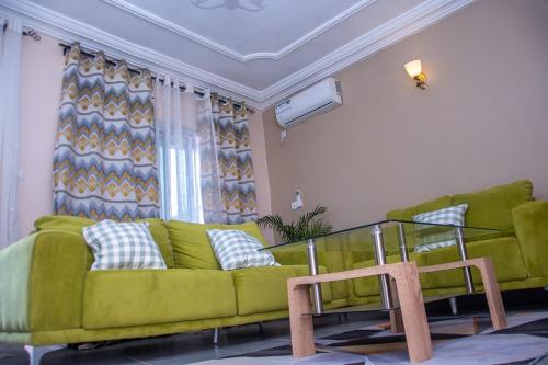 a living room with a green couch and a chair at New 237 de Luxe in Yaoundé