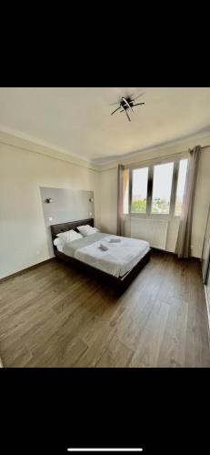 - une grande chambre avec un grand lit et du parquet dans l'établissement Appartement face velodrome, à Marseille