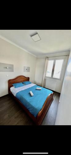 une chambre avec un lit avec des draps bleus et une fenêtre dans l'établissement Appartement face velodrome, à Marseille